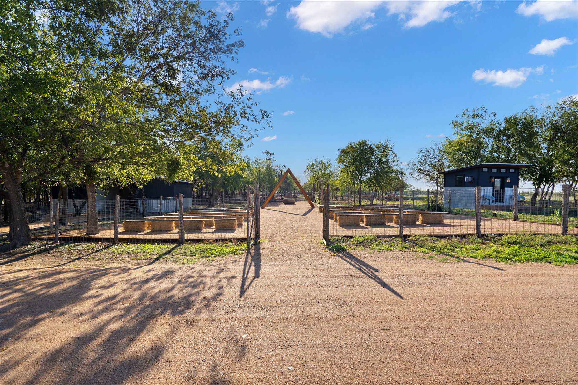 Open ranch gates leading to the timber ceremony arch
