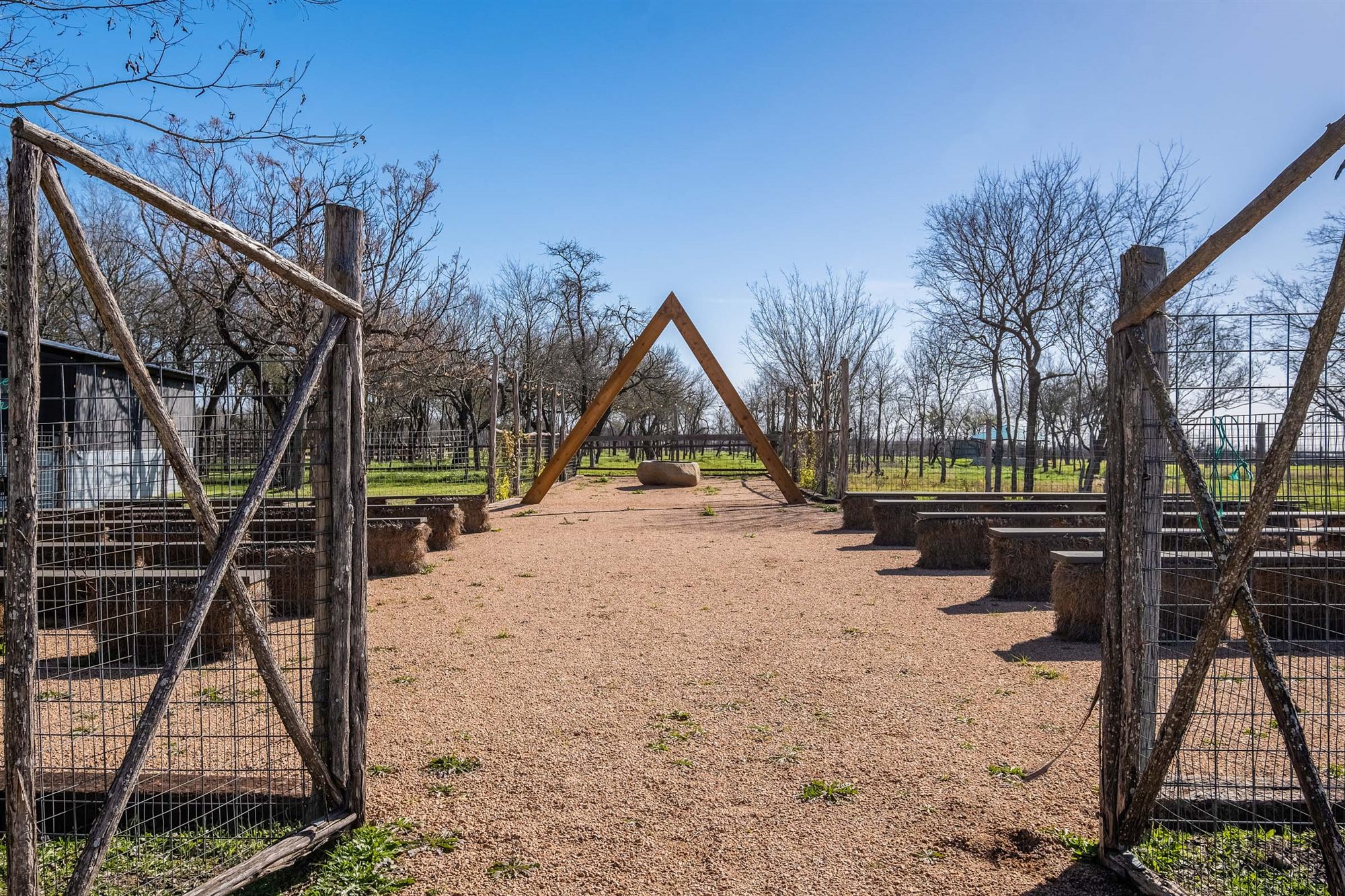 Rustic ceremony aisle framed by open ranch gates